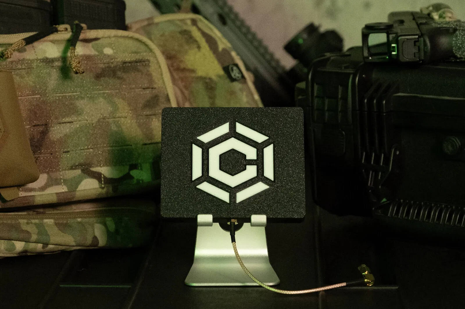 Carbon ISR conformal antenna element in a laser-cut housing, bench-mounted beside field kit